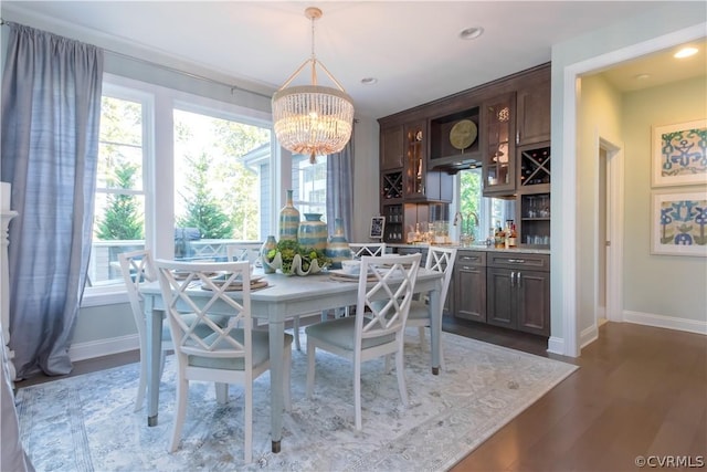 dining room featuring sink, hardwood / wood-style floors, and a notable chandelier