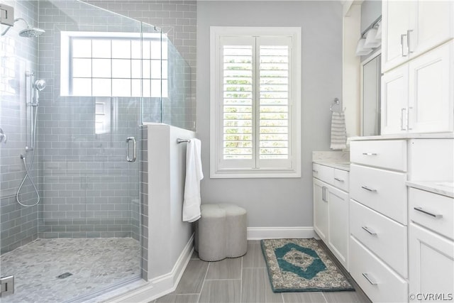 bathroom with tile patterned floors, vanity, and a shower with door