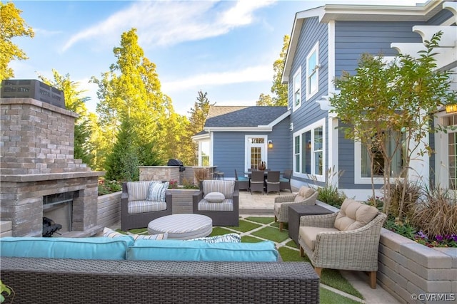 view of patio with an outdoor living space with a fireplace