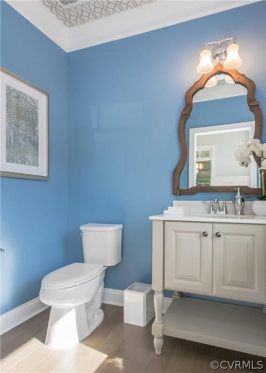 bathroom featuring crown molding, vanity, and toilet