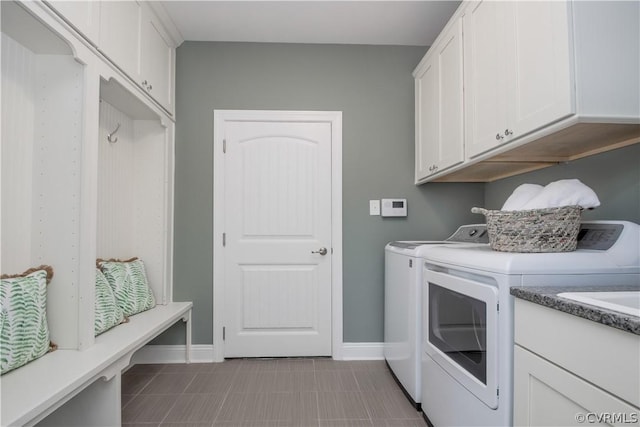 laundry room featuring washer and clothes dryer and cabinets