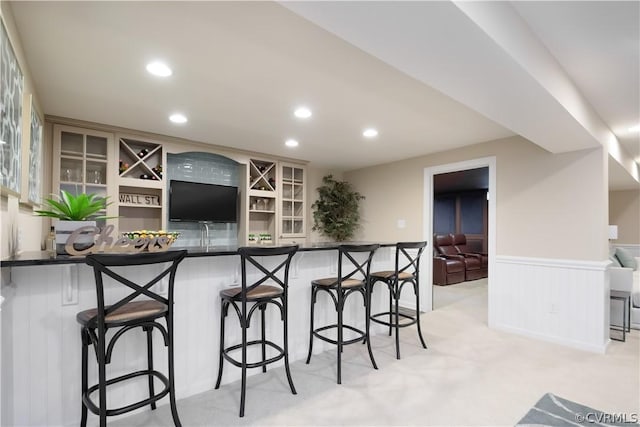 kitchen with a kitchen bar, kitchen peninsula, and light carpet