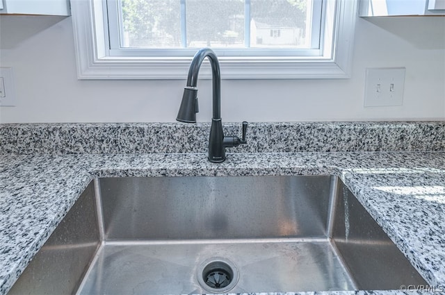 interior details featuring light stone counters and sink