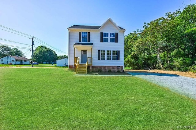 view of front of home with gravel driveway and a front lawn