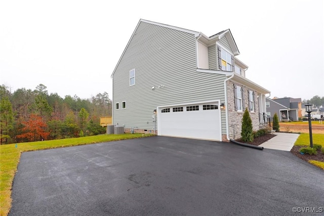 view of side of property with central air condition unit and a garage