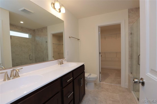 bathroom with vanity, toilet, and a shower with shower door