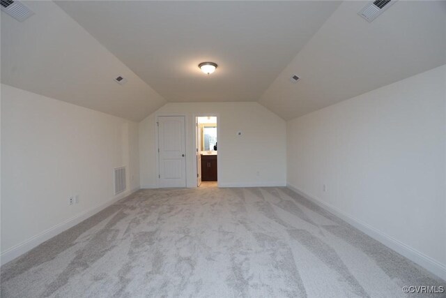 bonus room featuring light carpet and lofted ceiling