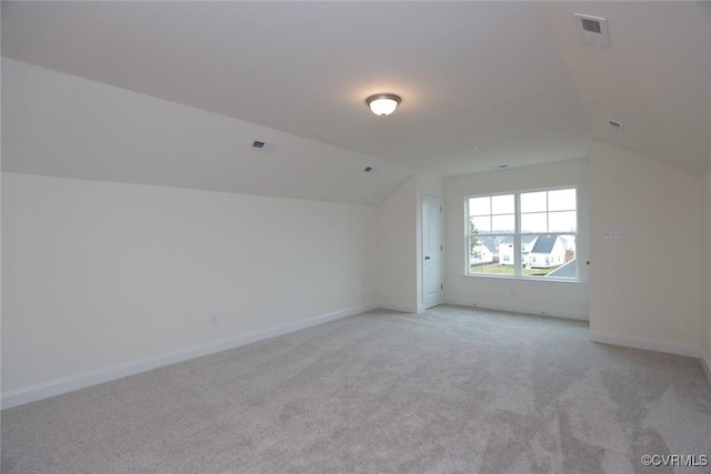 bonus room featuring light carpet and vaulted ceiling