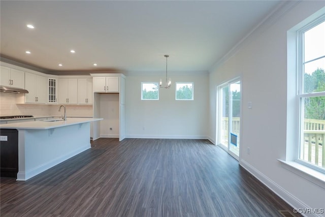 kitchen featuring sink, hanging light fixtures, dark hardwood / wood-style floors, crown molding, and white cabinets