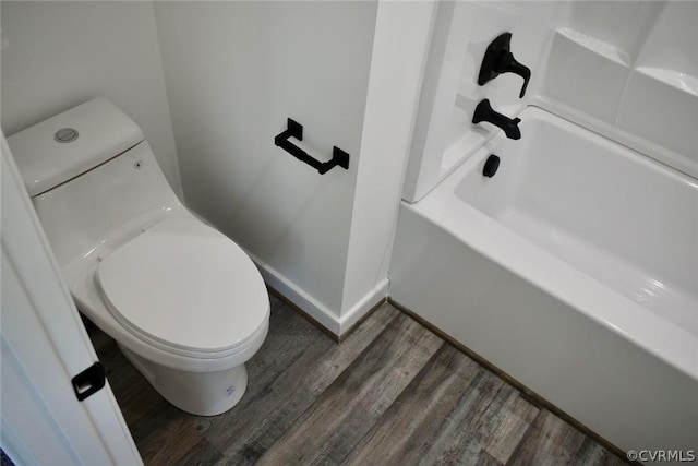 bathroom featuring a washtub, hardwood / wood-style flooring, and toilet