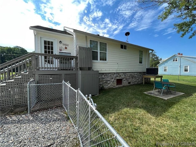 rear view of property with fence, central air condition unit, stairway, a lawn, and a patio area