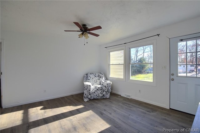 unfurnished room featuring ceiling fan, plenty of natural light, and dark wood-type flooring