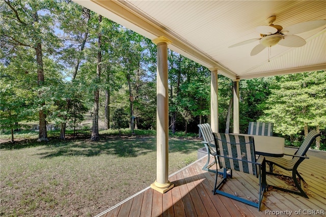 wooden terrace with ceiling fan and a yard