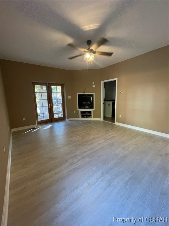 unfurnished living room with french doors, a textured ceiling, light hardwood / wood-style flooring, and ceiling fan