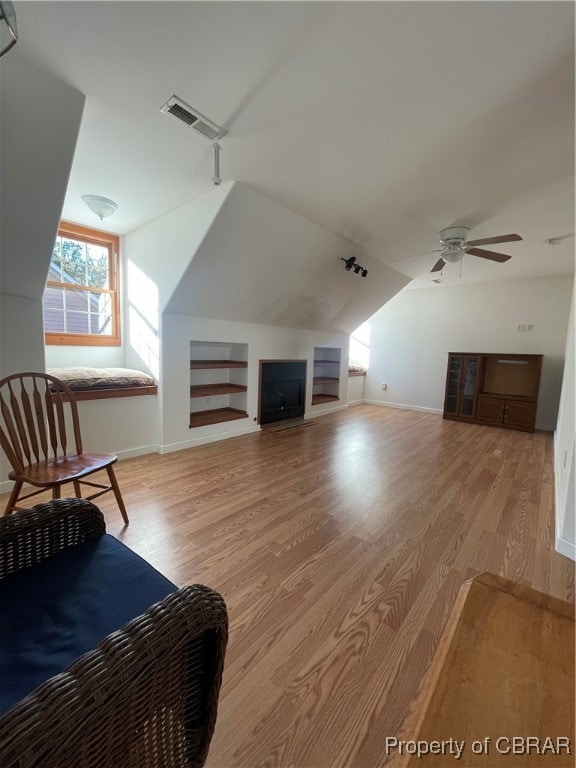 living room featuring light wood-type flooring, vaulted ceiling, and ceiling fan