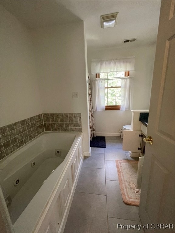 bathroom featuring a bathing tub, tile patterned flooring, vanity, and toilet