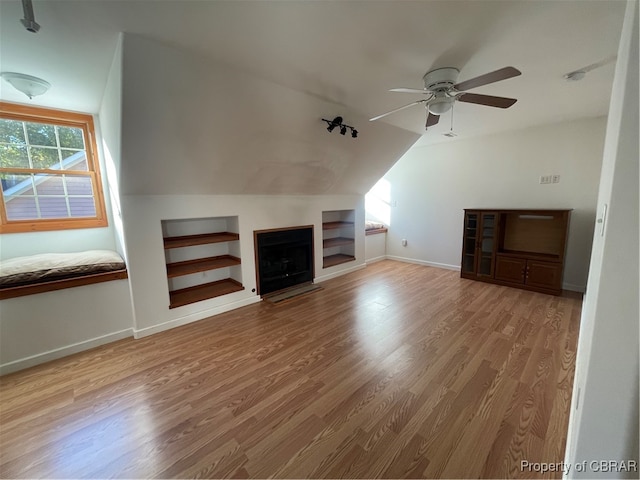 unfurnished living room featuring wood-type flooring, vaulted ceiling, and ceiling fan