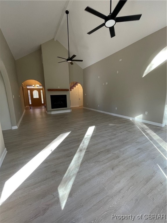 unfurnished living room with high vaulted ceiling and light hardwood / wood-style flooring