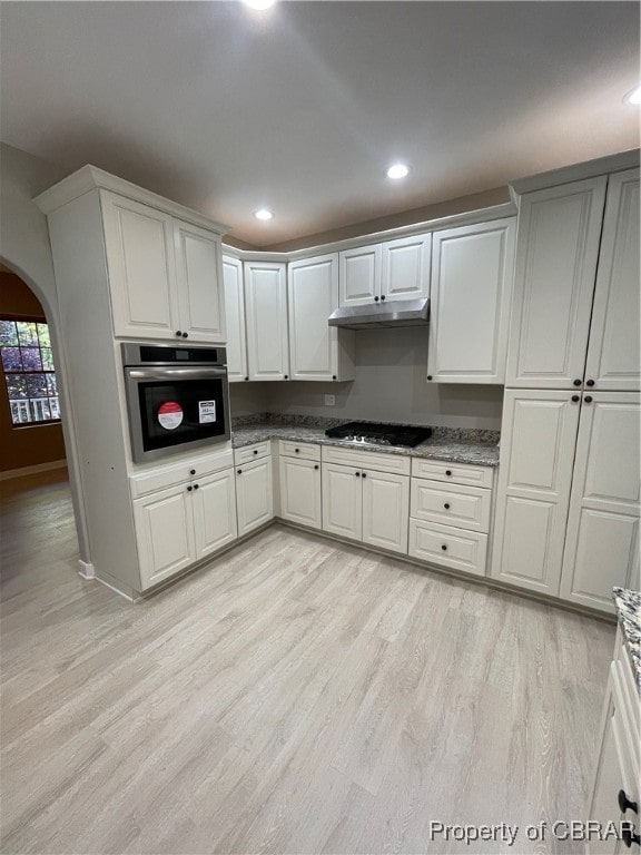 kitchen featuring stainless steel oven, gas stovetop, and white cabinetry