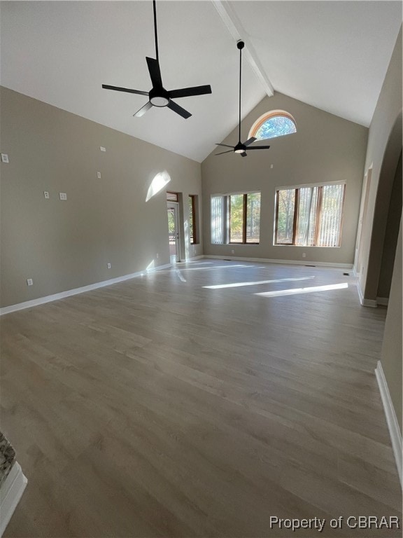 unfurnished living room featuring hardwood / wood-style floors, ceiling fan, beam ceiling, and high vaulted ceiling