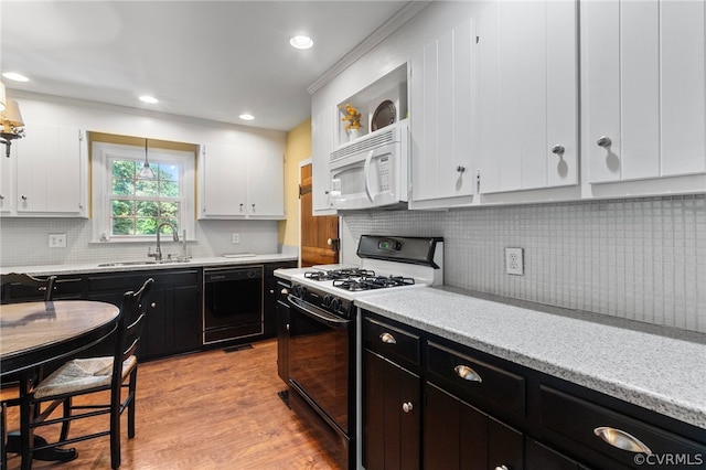 kitchen with white appliances, sink, backsplash, light hardwood / wood-style floors, and white cabinetry