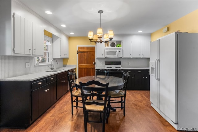 kitchen with backsplash, sink, white appliances, and light wood-type flooring