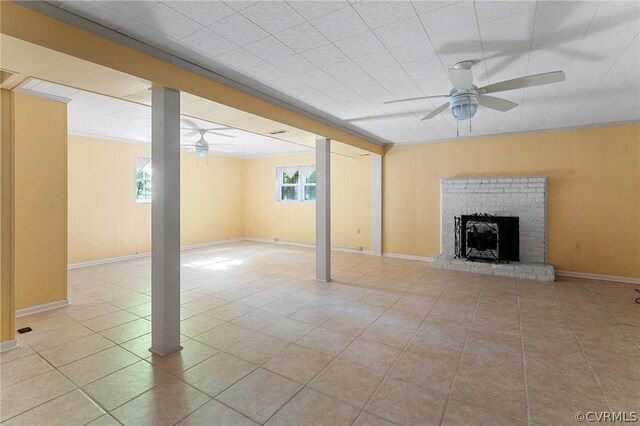 unfurnished living room with a fireplace, light tile patterned floors, plenty of natural light, and ceiling fan