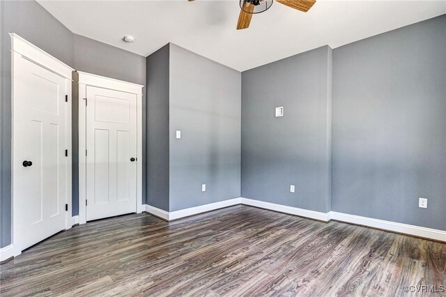 empty room with ceiling fan and dark hardwood / wood-style floors