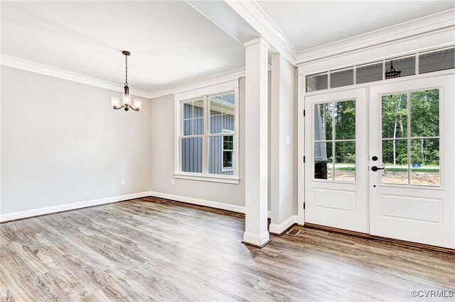 doorway featuring ornamental molding, hardwood / wood-style floors, a chandelier, and french doors