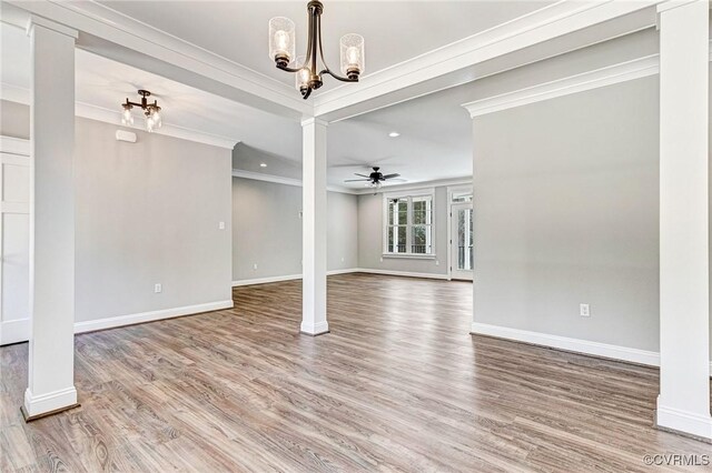 empty room featuring hardwood / wood-style flooring, ceiling fan with notable chandelier, and ornamental molding