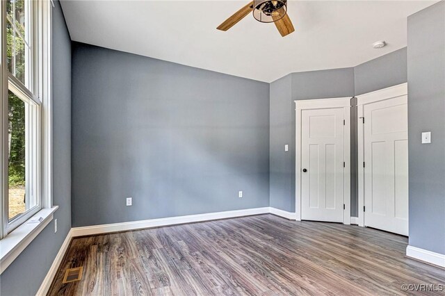 unfurnished room featuring wood-type flooring, ceiling fan, and a healthy amount of sunlight