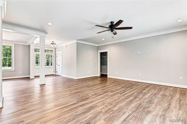 unfurnished living room with light wood-type flooring, ceiling fan, decorative columns, and crown molding