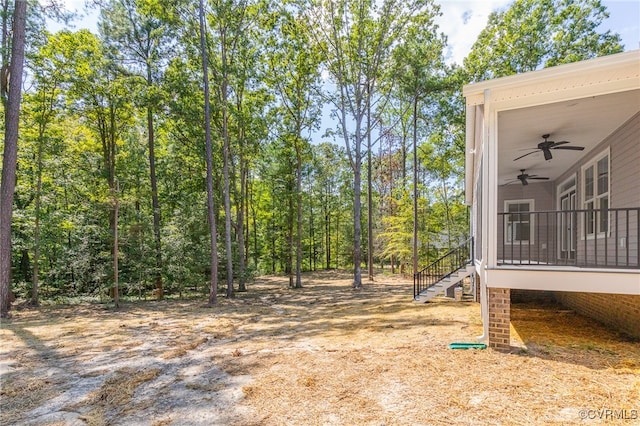 view of yard featuring ceiling fan and a deck