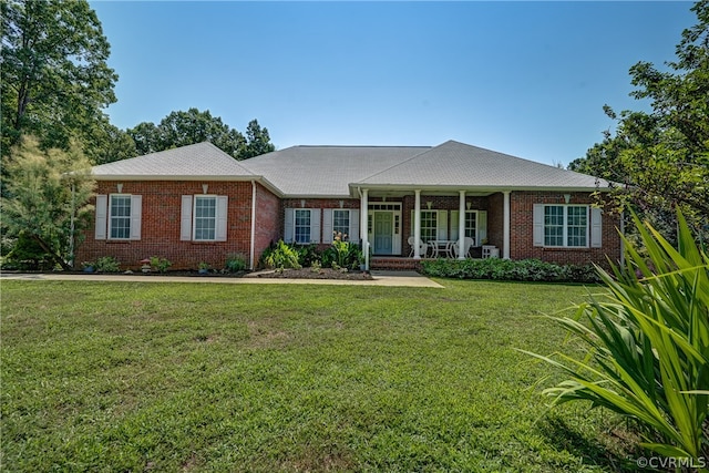 ranch-style home featuring covered porch and a front lawn