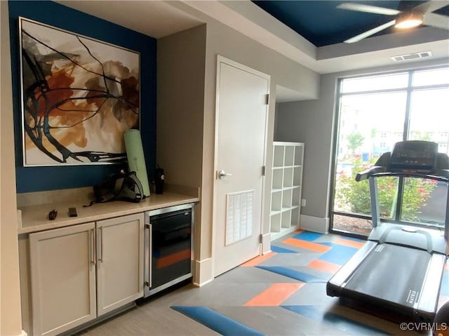 interior space with a dry bar, baseboards, wine cooler, and visible vents