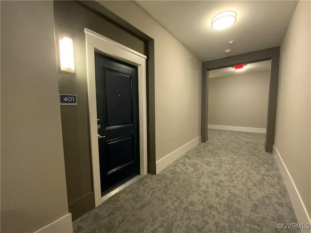 hallway with carpet flooring and baseboards