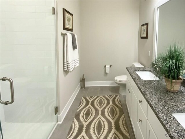 bathroom with dual vanity, toilet, tile patterned flooring, and an enclosed shower