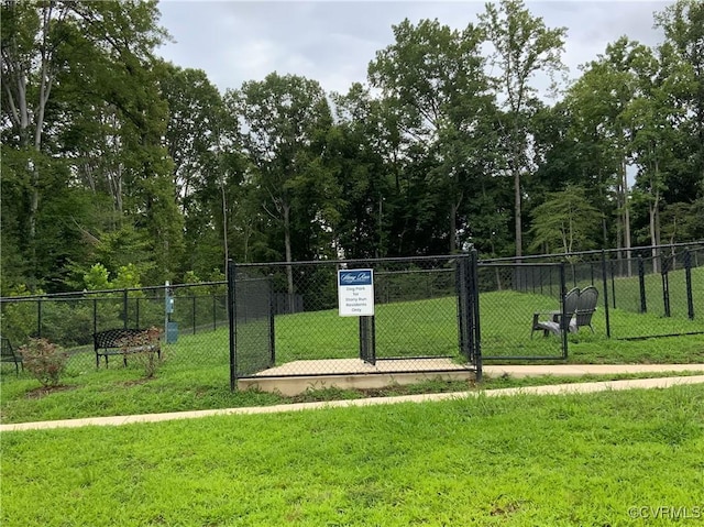 view of home's community with a gate, a lawn, and fence