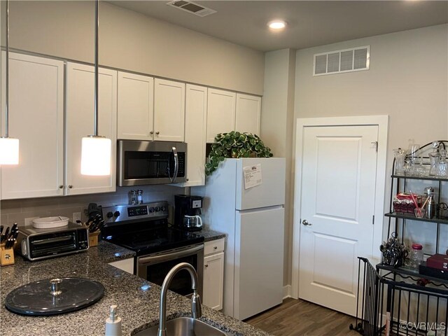 kitchen featuring dark stone counters, stainless steel appliances, white cabinets, sink, and dark hardwood / wood-style floors