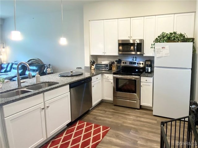 kitchen with white cabinets, dark wood-type flooring, stainless steel appliances, and a sink