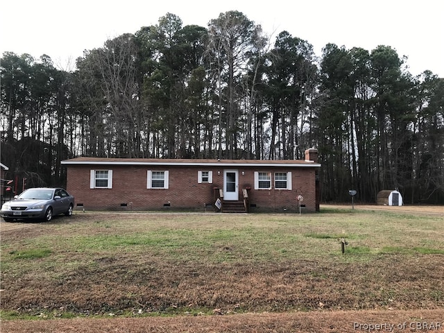 ranch-style house with a storage shed and a front yard