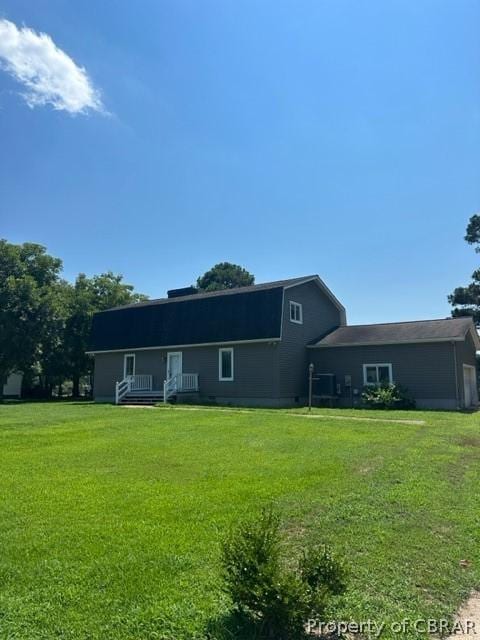 rear view of house with a lawn and a gambrel roof