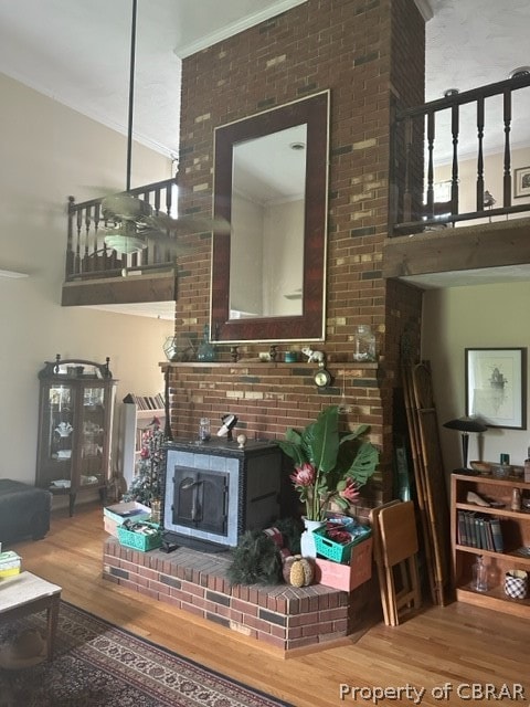 living room featuring brick wall, crown molding, and hardwood / wood-style floors