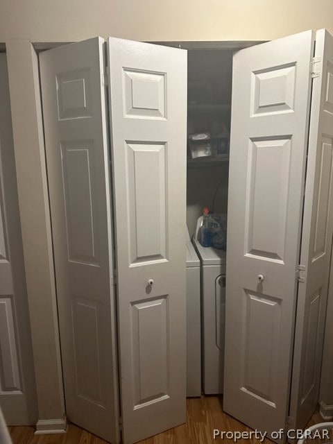 laundry room with washer and dryer and hardwood / wood-style floors