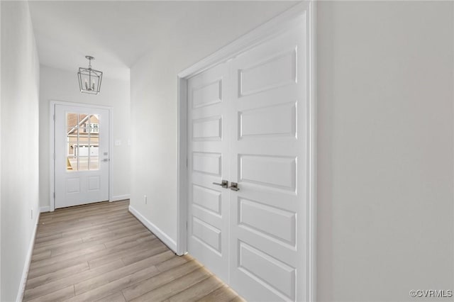 doorway featuring light hardwood / wood-style floors and an inviting chandelier