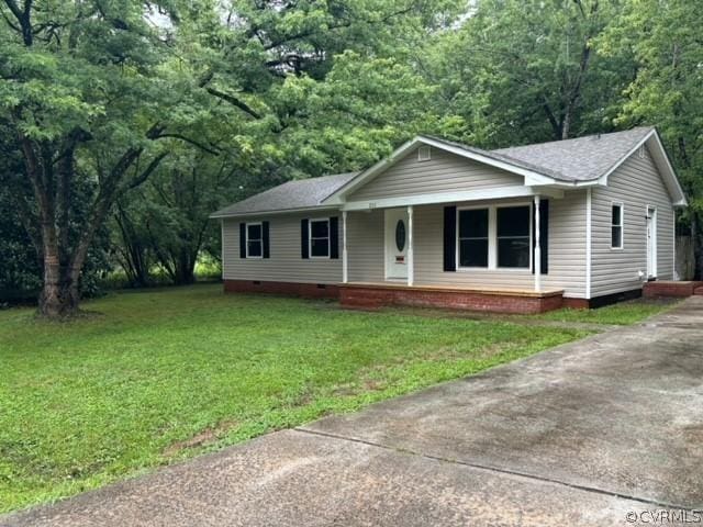 ranch-style home with a front yard, a wooded view, covered porch, and crawl space