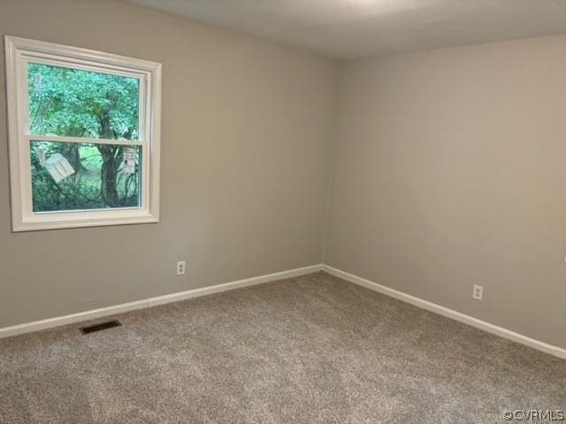 spare room featuring visible vents, baseboards, and carpet floors