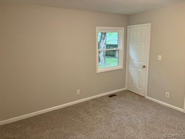 carpeted spare room with visible vents and baseboards