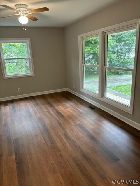 spare room with visible vents, dark wood-style floors, baseboards, and ceiling fan