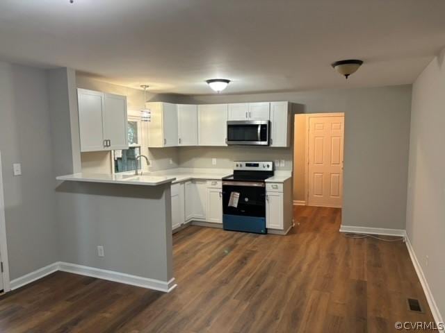 kitchen with stainless steel microwave, white cabinets, light countertops, and electric stove